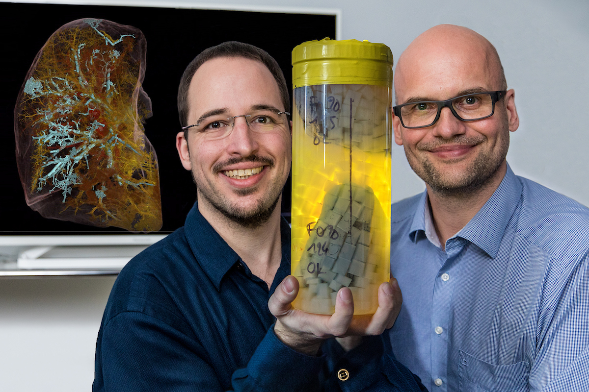 Professor Dr. Danny Jonigk (rechts) und Christopher Werlein mit dem linken Oberlappen eines COVID-19-Verstorbenen in einem für die Messung im HiP-CT geeigneten Spezialbehälter (©Karin Kaiser / MHH)