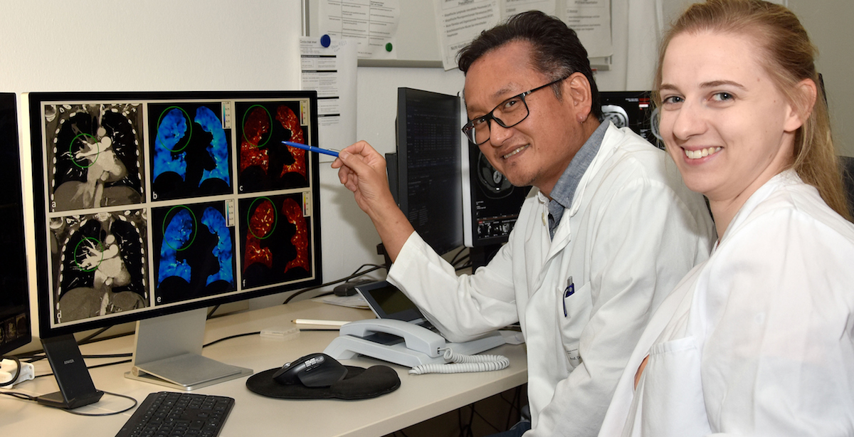 Professor Shin (links) und Dr. Scharm begutachten anhand der CT-Aufnahmen die Struktur (grau), die Belüftung (blau) und die Durchblutung (rot) einer Lunge (© Heike Steinlandt/MHH)